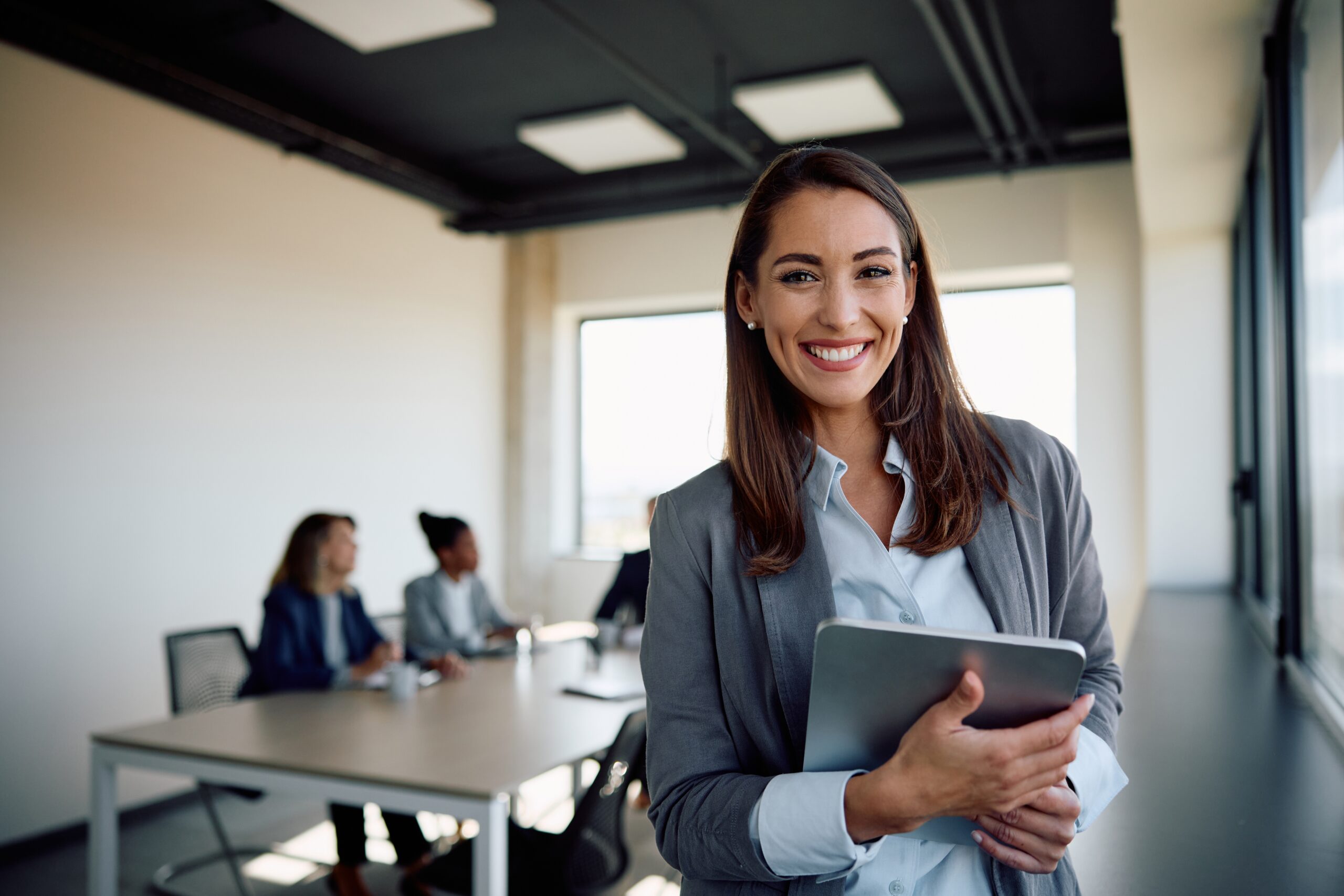 A happy business professional looking confident in the boardroom